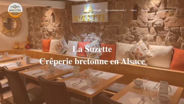 Capture d'écran du site web de La Suzette, une crêperie bretonne située en Alsace. L'image contient une photo de la grande salle du restaurant.